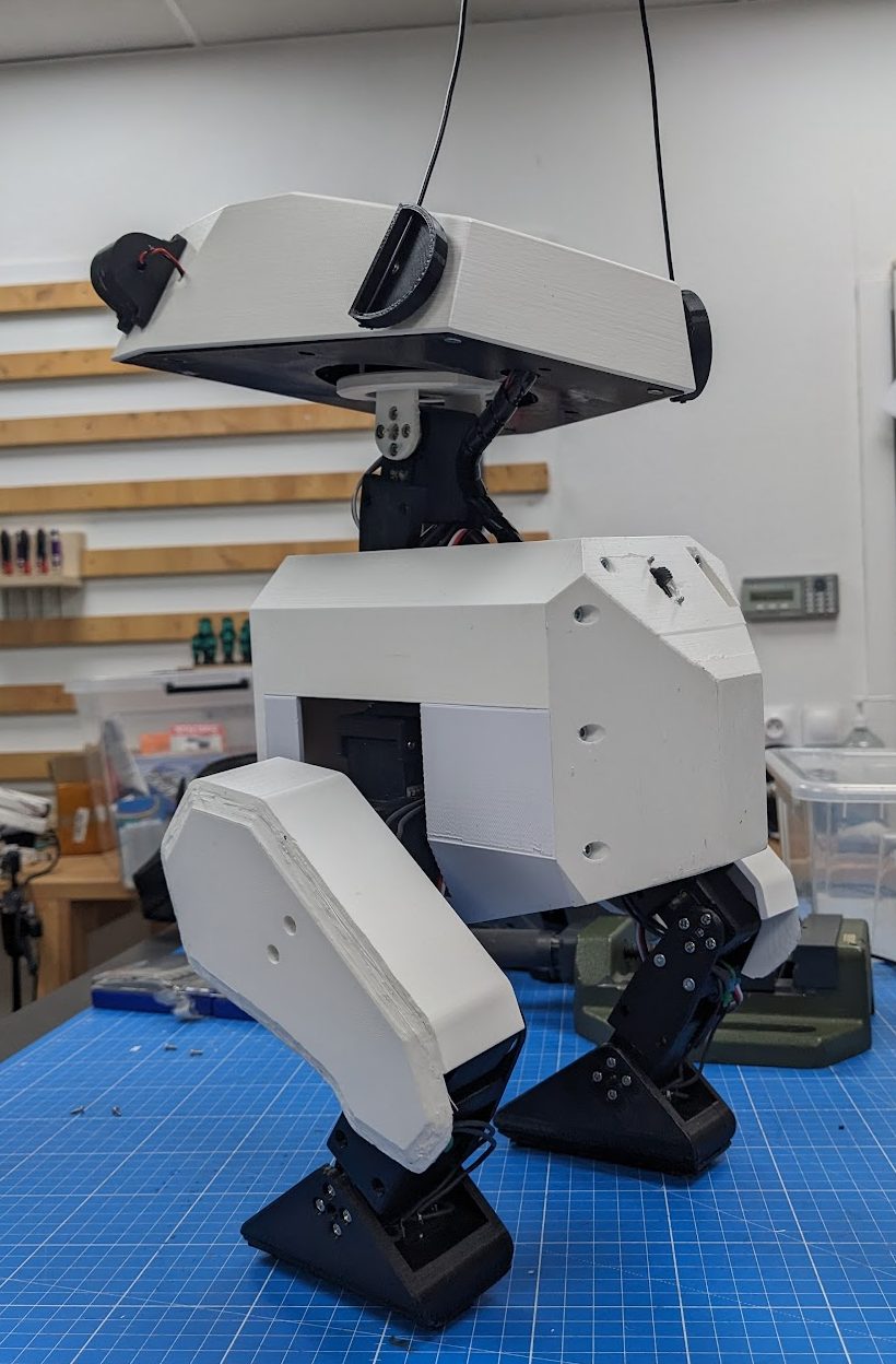 Three-quarter side view of the Open Duck Mini v2 robot showing its white printed shell, head and jointed legs